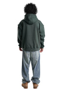 Person wearing a green hoodie and light blue jeans on a white background